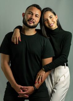 a man and woman are posing for a photo with their arms wrapped around each other