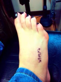 a woman's foot with a small tattoo on it