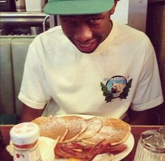 a man sitting at a table with a plate of food in front of him