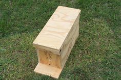 a wooden box sitting in the grass on top of a green field with words written on it