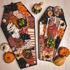 two trays filled with halloween food on top of a table