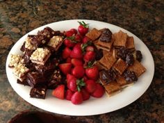 a white plate topped with lots of different types of food on top of a table