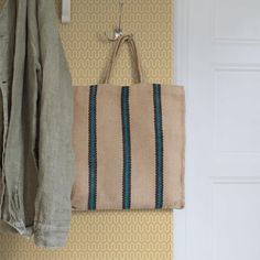 a bag hanging on the wall next to a coat rack