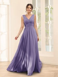 a woman in a long purple dress posing for the camera