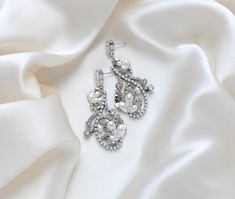 Accentuate your bridal ensemble with our exquisite LISA earrings. Handcrafted to order with Austrian crystals and pearls, these rhodium plated earrings exude luxury and sophistication. The delicate silver floral design adorned with white opal crystals will add a touch of elegance to your special day. - Handcrafted in my PA studio- Clear and white opal Austrian crystals and pearls- Rhodium (silver) plated- Earrings measure 2.5 inches x 1.25 inch- Handcrafted in the US.- Nickel free and hypoallerg Glamorous White Gold Crystal Earrings For Wedding, Elegant White Gold Crystal Bridal Earrings, Exquisite Silver Bridal Earrings With Diamond Accents, Luxury Crystal Bridal Earrings For Wedding, Elegant Crystal Earrings With Sparkling Stones For Wedding, Elegant White Gold Chandelier Earrings With Crystals, Elegant White Gold Crystal Chandelier Earrings, Luxury Silver Crystal Earrings For Wedding, Elegant Crystal Embellished Bridal Earrings For Anniversary