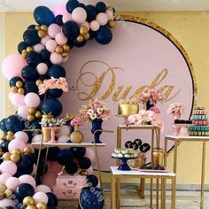 a party with balloons, cake and desserts on the table in front of a pink wall