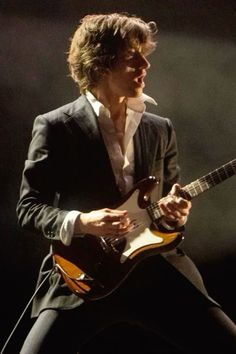 a man playing an electric guitar on stage