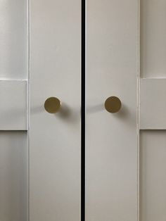 two white cupboards with brass handles and knobs