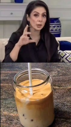 a woman holding a straw in her hand next to a jar filled with liquid on the table