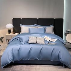 a bed with blue sheets and pillows in a room