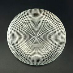 a glass plate with an intricate design on the bottom and sides, sitting on a black surface