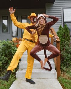 two people dressed in costumes standing on steps with their hands up and one person wearing a monkey costume