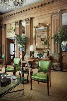 a living room filled with lots of furniture next to a chandelier and mirror