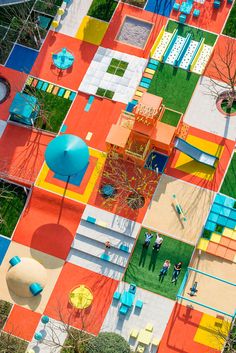 an aerial view of a colorful park with benches and tables