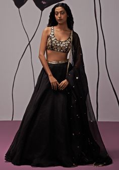 Featuring a stunning black lehenga crafted from silk organza, accented with a embroidered belt for added allure. Paired elegantly with a crepe blouse featuring intricate gold embroidered floral motifs and topped off with an embroidered dupatta with tassels. Ideal choice for adding a luxurious touch to Sangeet outfit. Composition : Blouse - Crepe, Lehenga -Silk Organza, Dupatta - Silk Organza Care: Dry Clean Only and Vacuum Storage This product can be customized for sleeves, length of blouse and neckline Delivery : 4-6 weeks as the product is hand crafted. Check Size Guide or choose MySize for free customisation (All Sizes above XL can be made at 15% additional cost) For more information and sizes please contact fabiliciousfashion@gmail.com or visit our Copenhagen studio. About the Designer Black Lengha Outfit, Lehenga Shoot, Black Sequin Lehenga, Black And Gold Lehenga, Crepe Lehenga, Lehenga Black, Black Sequin Blouse, Gold Organza, Applique Blouse