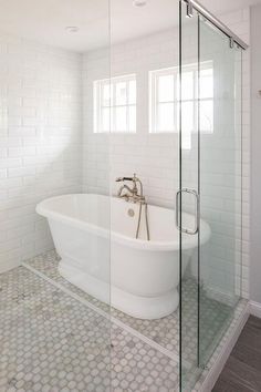 a white bath tub sitting next to a walk in shower