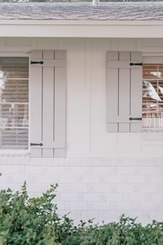 a white house with shutters on the windows