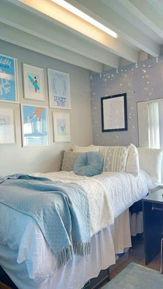 a bed sitting in a bedroom next to a window with pictures on the wall above it