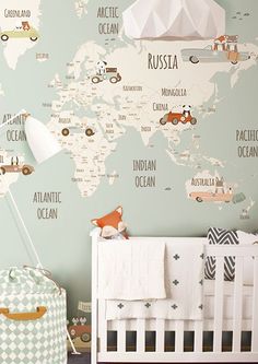 a baby's room with a crib and map wallpaper on the walls