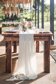 the table is set with white linens and place settings for an elegant dinner party