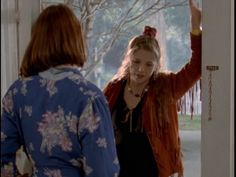 two women standing in front of a door with their hands up and one woman holding her head