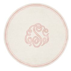 a white and pink monogrammed round rug with the letter s on it's center