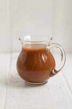 a glass pitcher filled with liquid sitting on top of a table