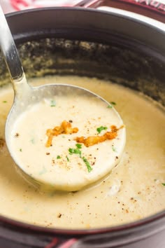 a ladle full of soup is being held by a spoon