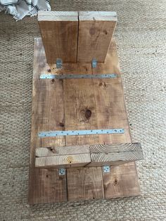 a wooden box sitting on top of a carpeted floor next to a pile of wood