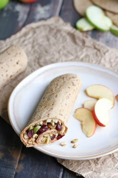 an apple, raisins and peanut butter wrap on a plate