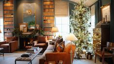 a living room filled with lots of furniture and a christmas tree in front of it