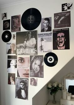 there is a wall with many pictures on it and a record hanging from the wall