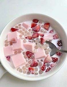 a white bowl filled with lots of different types of fruit and ice cream on top of a table