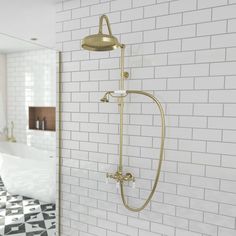 a white tiled bathroom with a gold shower faucet and black and white checkered floor