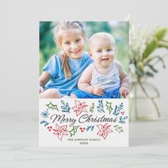 a christmas card with an image of two young children on the front and bottom, in white