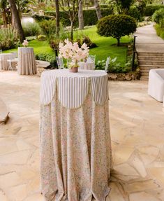 a table with flowers on it sitting in the middle of a patio