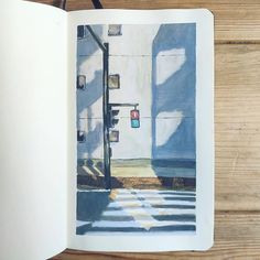 an open book on a wooden table with a drawing of a street light in it