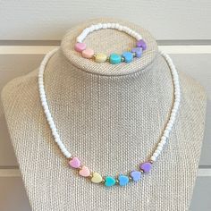 a necklace on a mannequin with hearts in pastel colors hanging from it