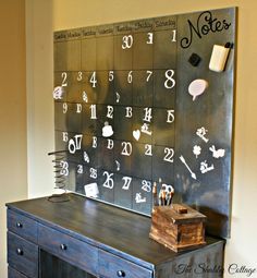 a desk with a chalkboard on it that has numbers and letters written on it