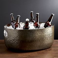 an ice bucket filled with beer bottles on top of a wooden table