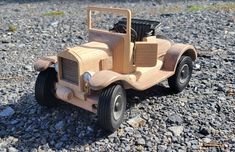 a wooden toy truck sitting on top of gravel