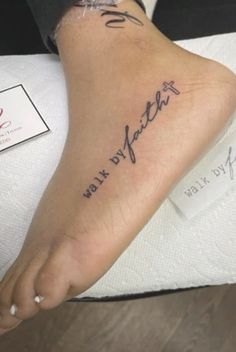 a woman's foot with the words walk by faith tattooed on her left leg