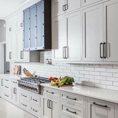 a kitchen with lots of white cabinets and counter tops, including a stove top oven