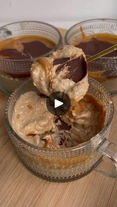 two bowls filled with ice cream and caramel sauce on top of a wooden table