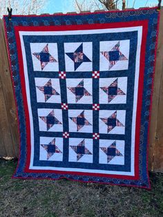 a blue and red quilt hanging on a fence