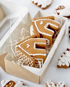 several ginger cookies in a box on a table next to other decorated cookies and utensils