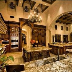 a large kitchen with marble counter tops and wooden cabinets