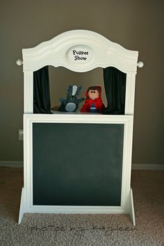 there is a chalkboard on the back of a toy bed with two stuffed animals in it