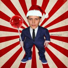 a man in a suit and tie holding a lollipop with a santa hat on