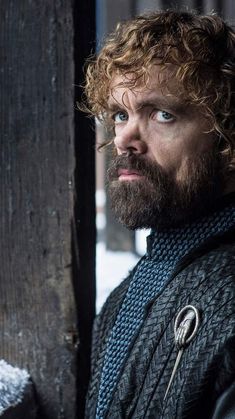 a close up of a person with a beard and wearing a jacket in the snow